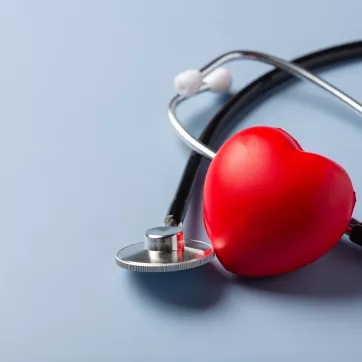 a foam heart with a stethoscope on a blue background