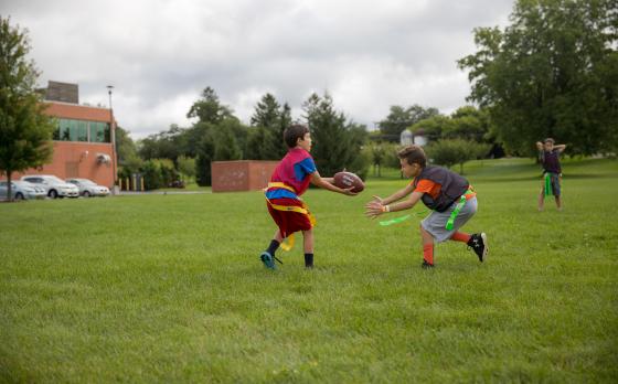 a group of kids playing flag football outside