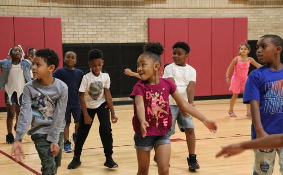 a group of kids dancing in a gym