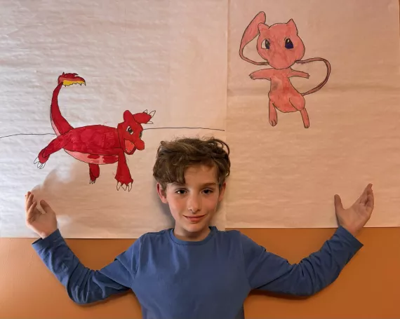 Mason poses in front of his Pokemon drawings