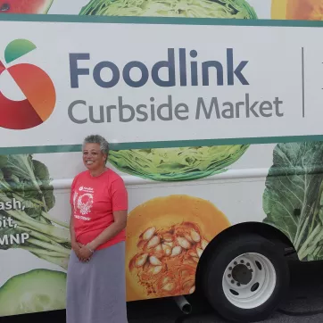 Flo from Foodlink standing in front of the Foodlink Curbside Market Food Truck