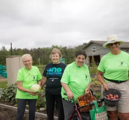 Volunteers in the garden holding baskets of vegetables