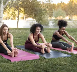 three women doing yoga outside