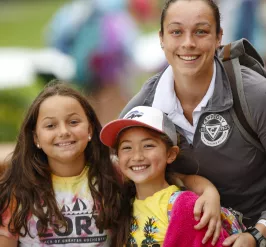A camp cory staff member with two campers smiling at the camera
