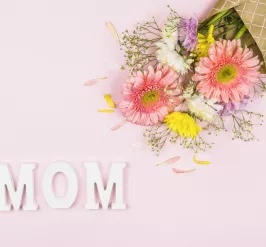 Letters spelling "MOM" below a bouquet of flowers
