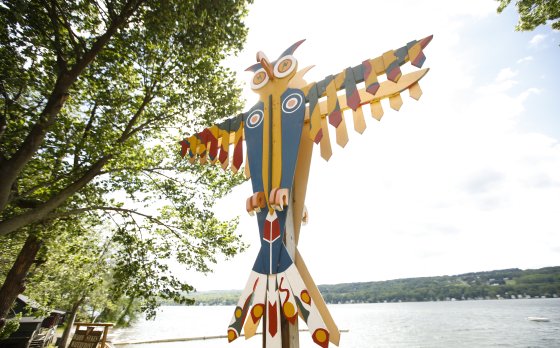 Photo of thunderbird totem at Camp Cory with lake in the background