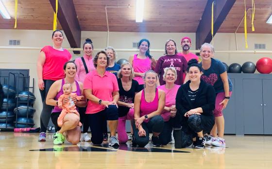 group of ymca members in pink pose for picture in pink class to raise awareness for breast cancer