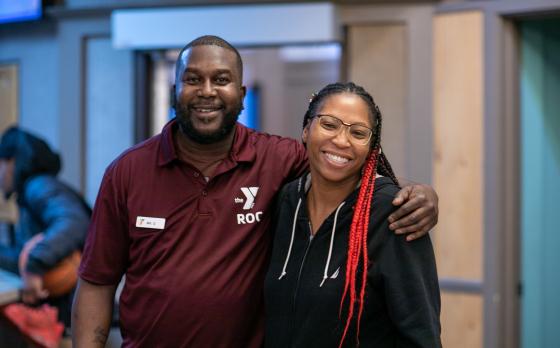 ymca staff and member pose for a picture, smiling together