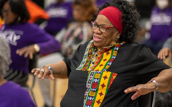 member of the YMCA of Greater Rochester smiles mid group exercise class