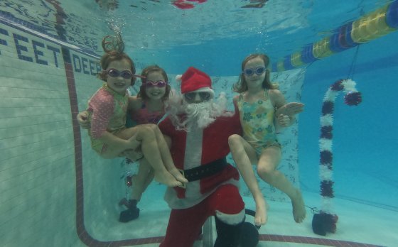 children smiling with santa underwater in the pool