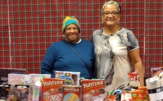 Fairy Grandparents standing behind table with Christmas gifts.