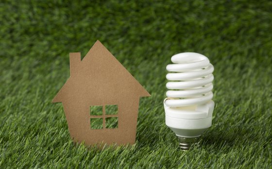 A cardboard cutout house and light bulb