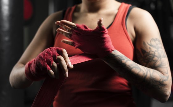 Women lacing up hands for fight training.