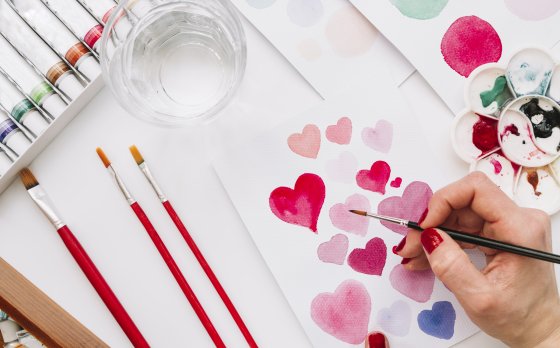 Hand painting hearts with paintbrush