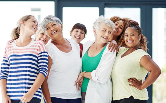 A diverse group of women standing together and smiling.