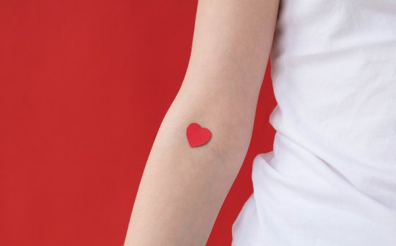 Arm with paper heart on inside of elbow