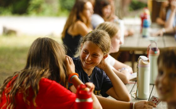 Two campers smiling, playing cards