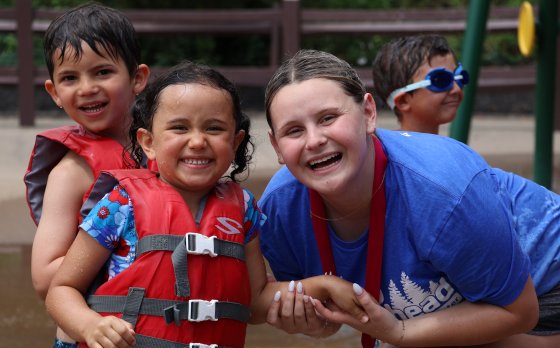 Camp counselor with campers on splash pad