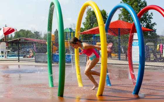 kid running through splash pad