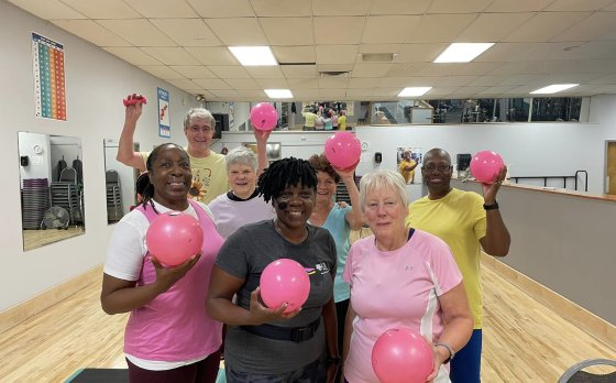 pink classes group holding pink exercise balls