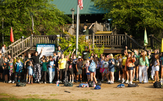 campers and counselors cheering at flagpole