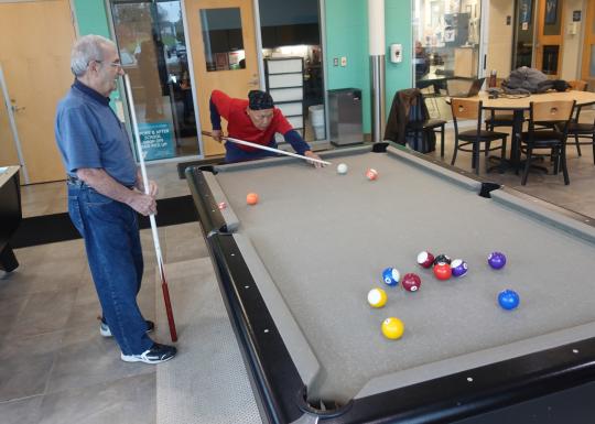 two gentlemen play billiards at the westside family ymca