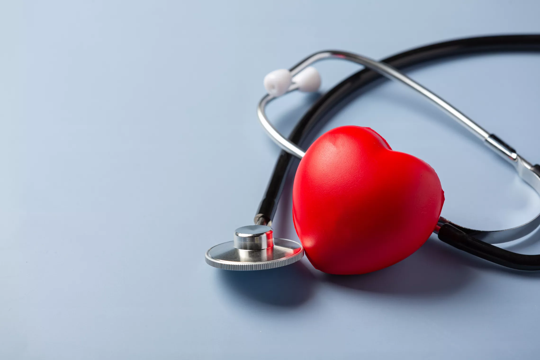 a foam heart with a stethoscope on a blue background