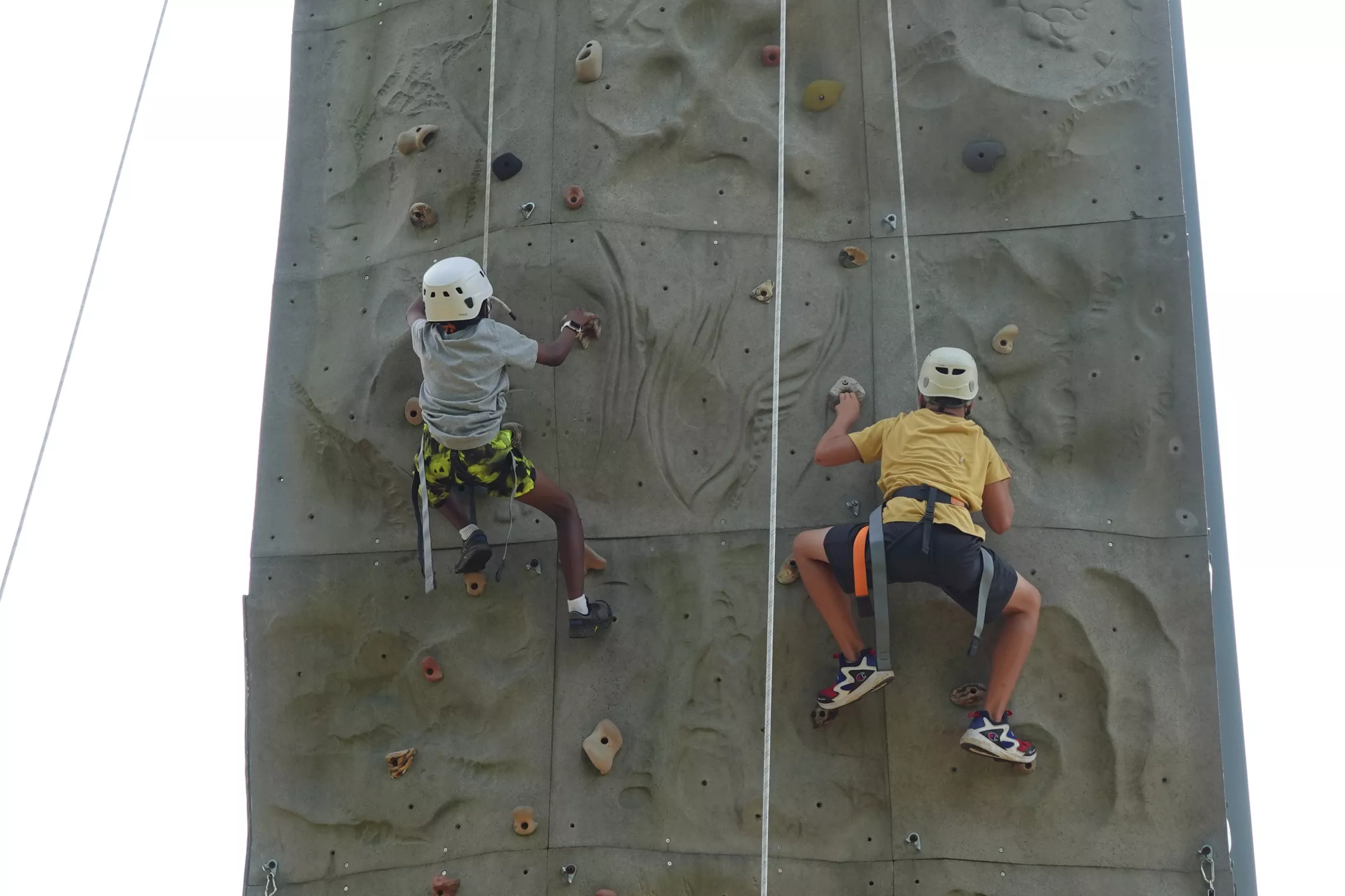 two boys climbing the outdoor rockwall at Camp Eastside