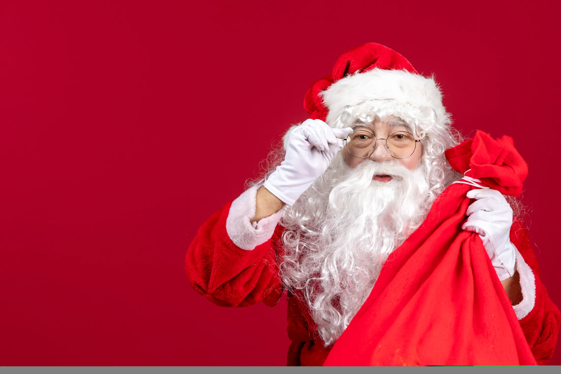 Santa with a red background holding a red sack