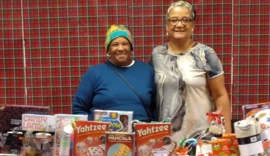 Fairy Grandparents standing behind table with Christmas gifts.