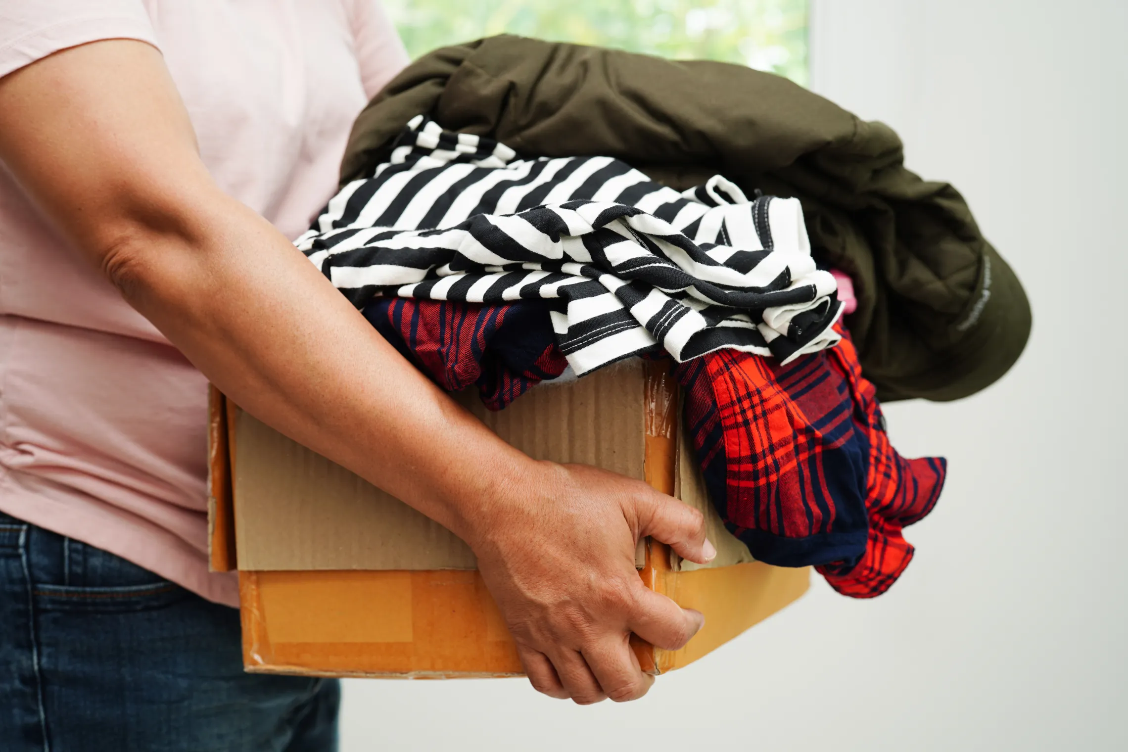 A man carrying a box of clothing.