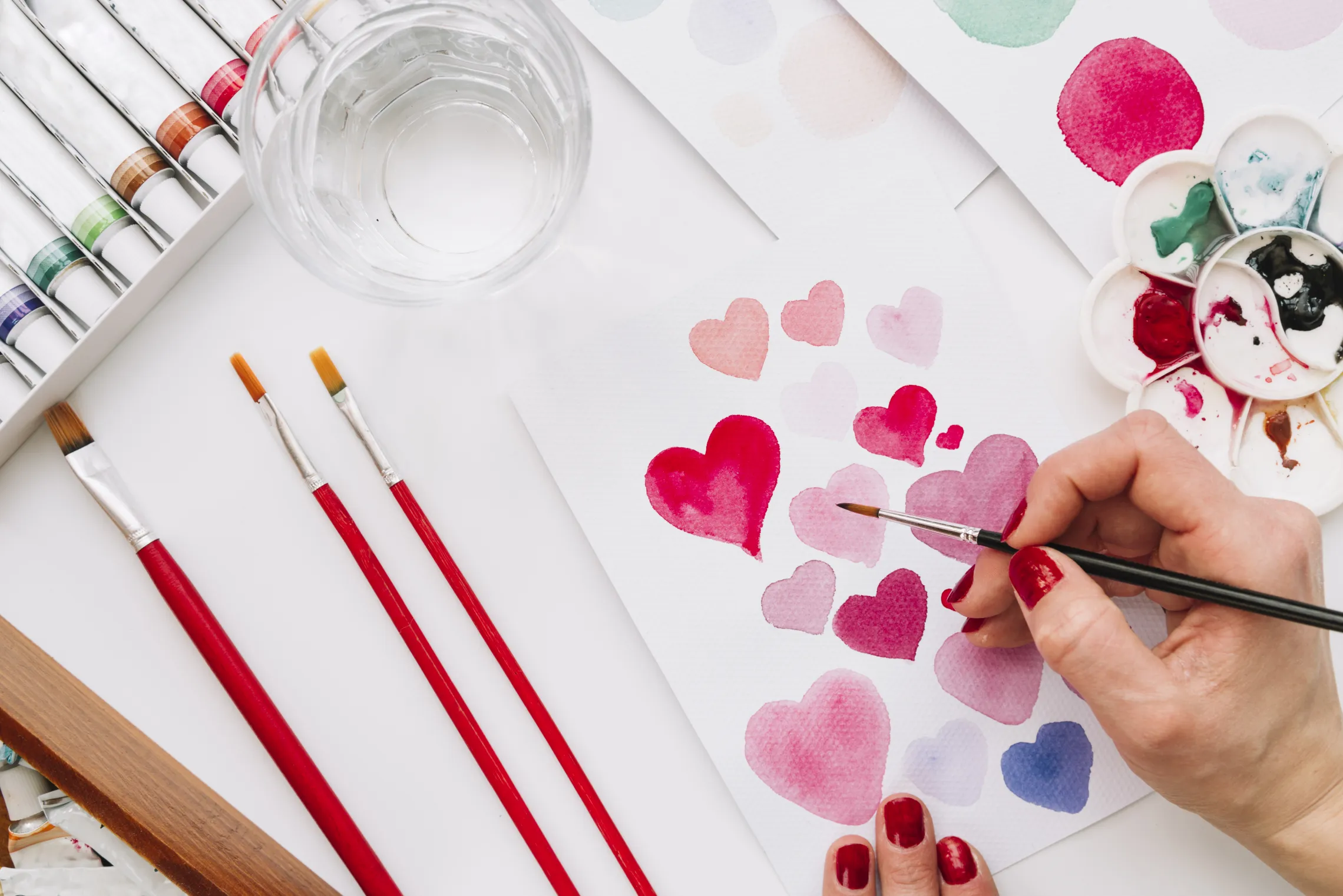 Hand painting hearts with paintbrush