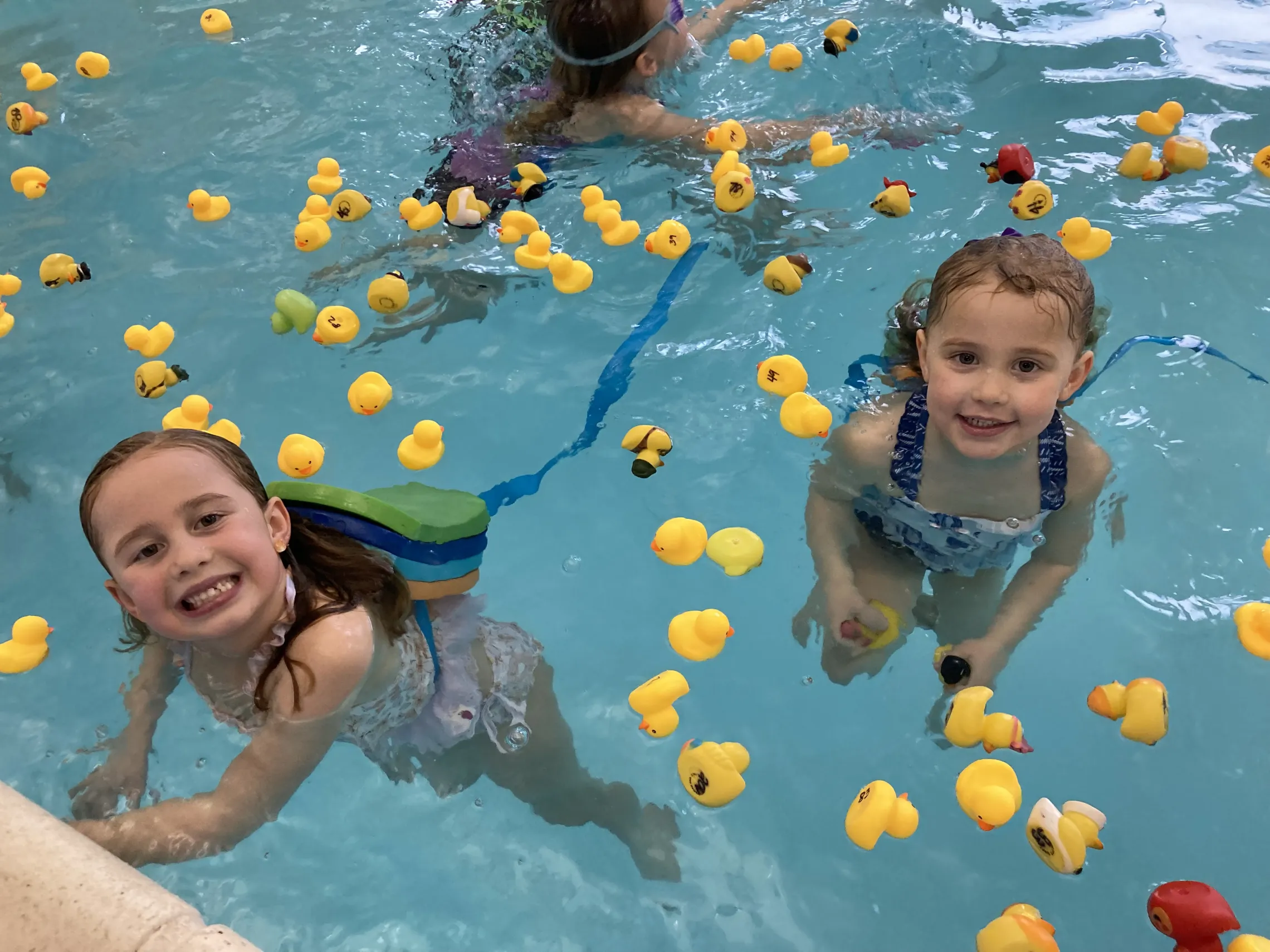 Children swimming with rubber ducks