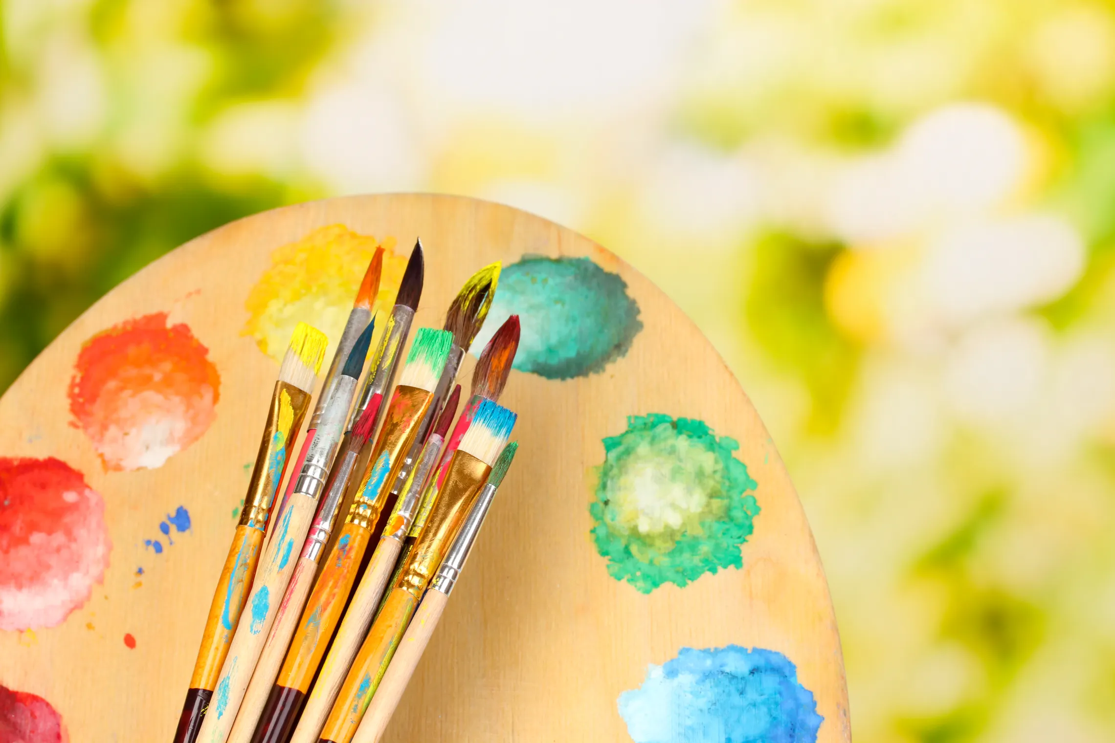 Paintbrushes and palette with nature background