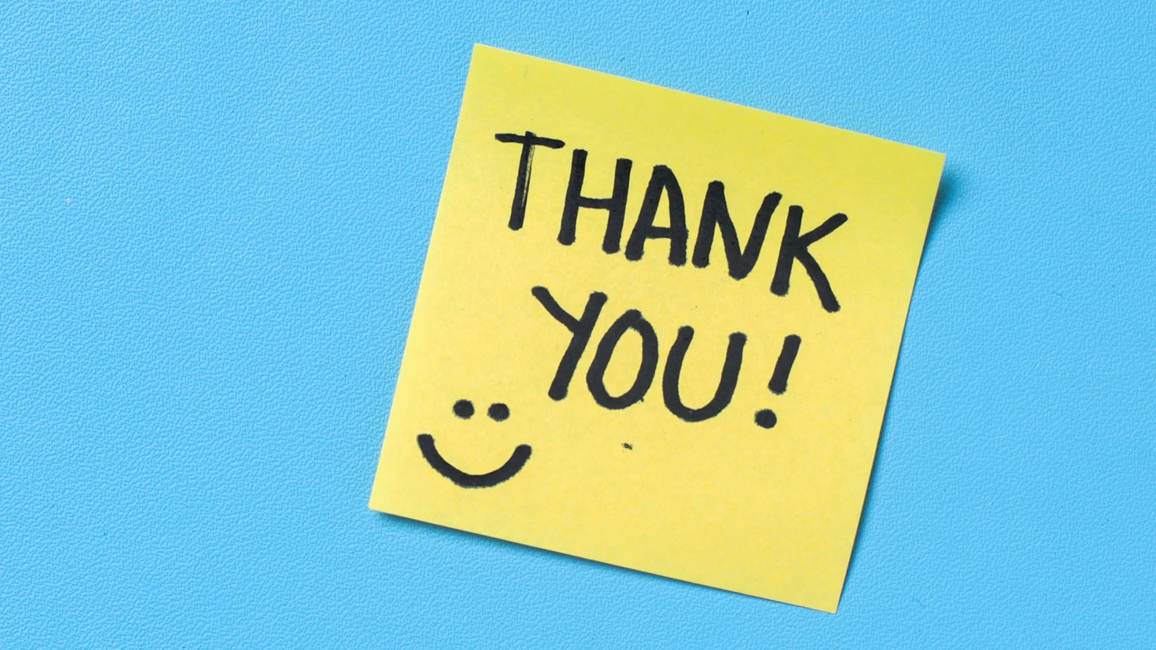 A sticky note reading "thank you!" with a smiley face.