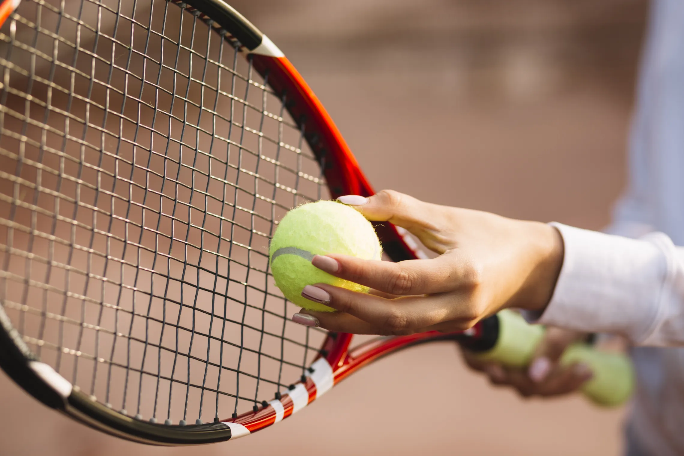 person holding tennis ball and racket