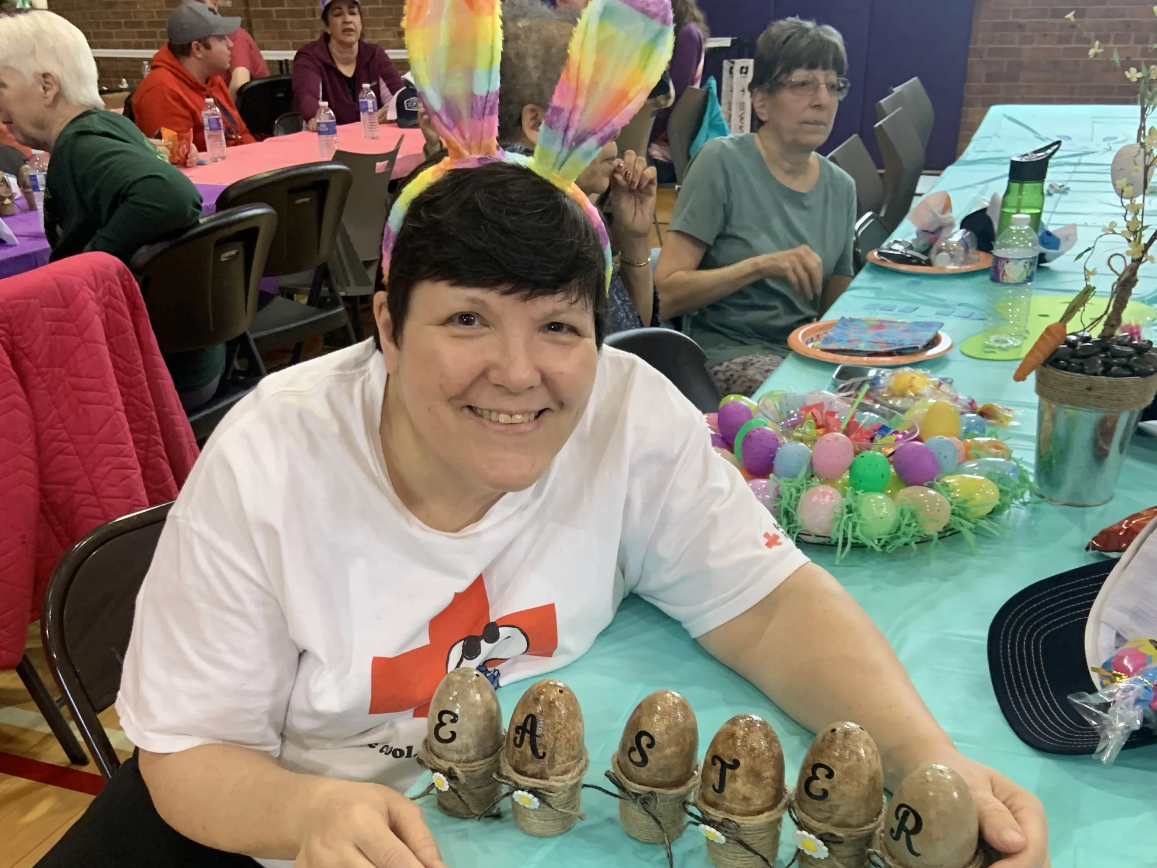 member wearing bunny ears with easter egg craft