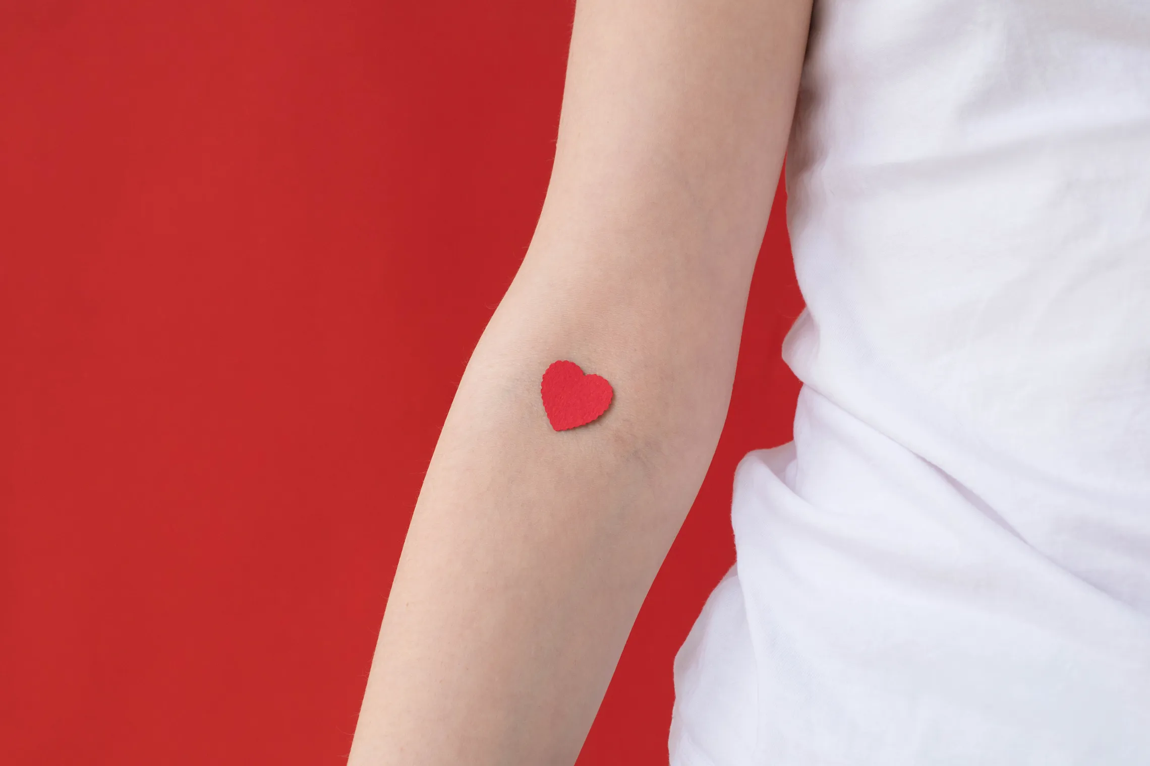 Arm with paper heart on inside of elbow