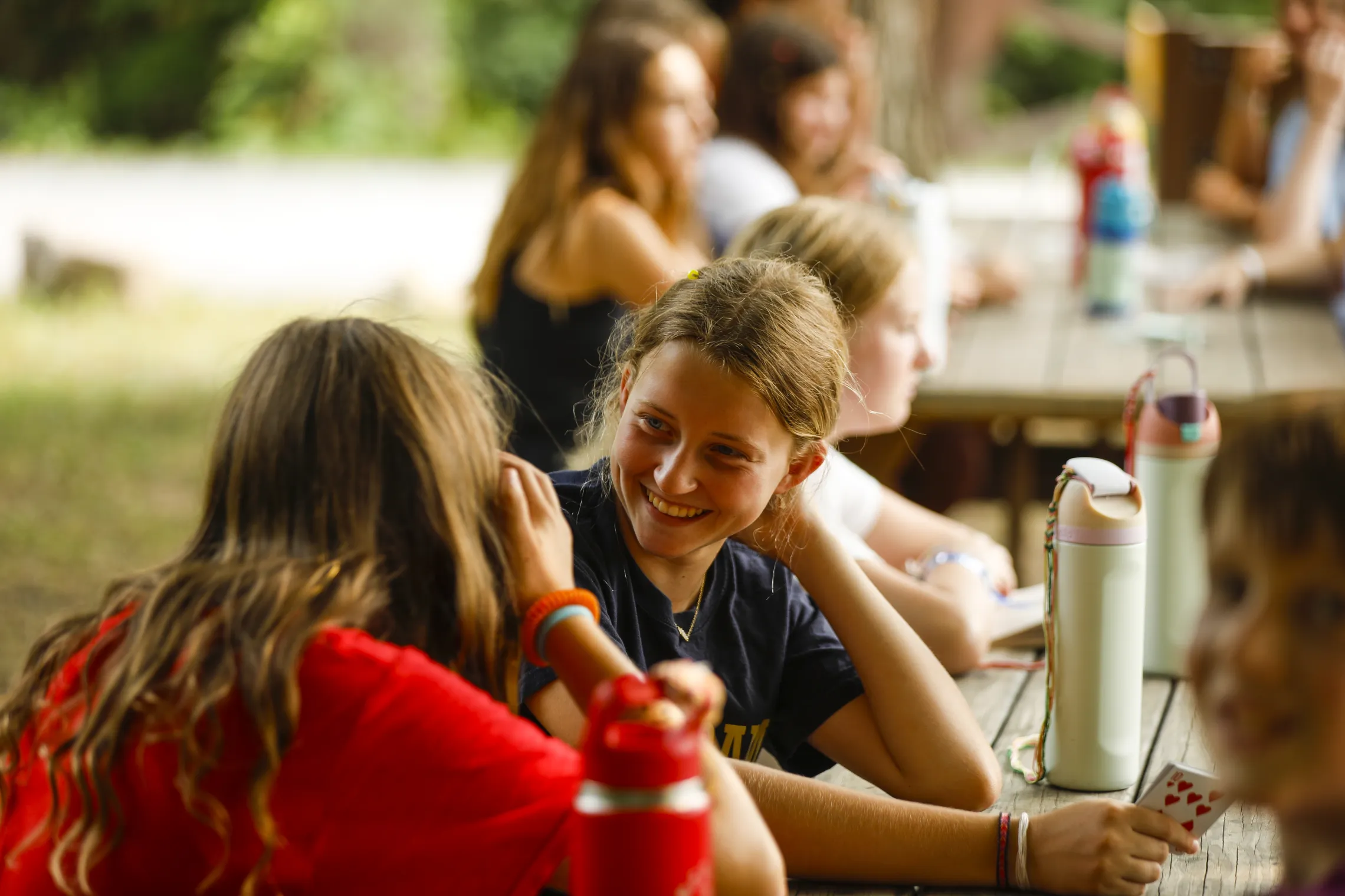 Two campers smiling, playing cards