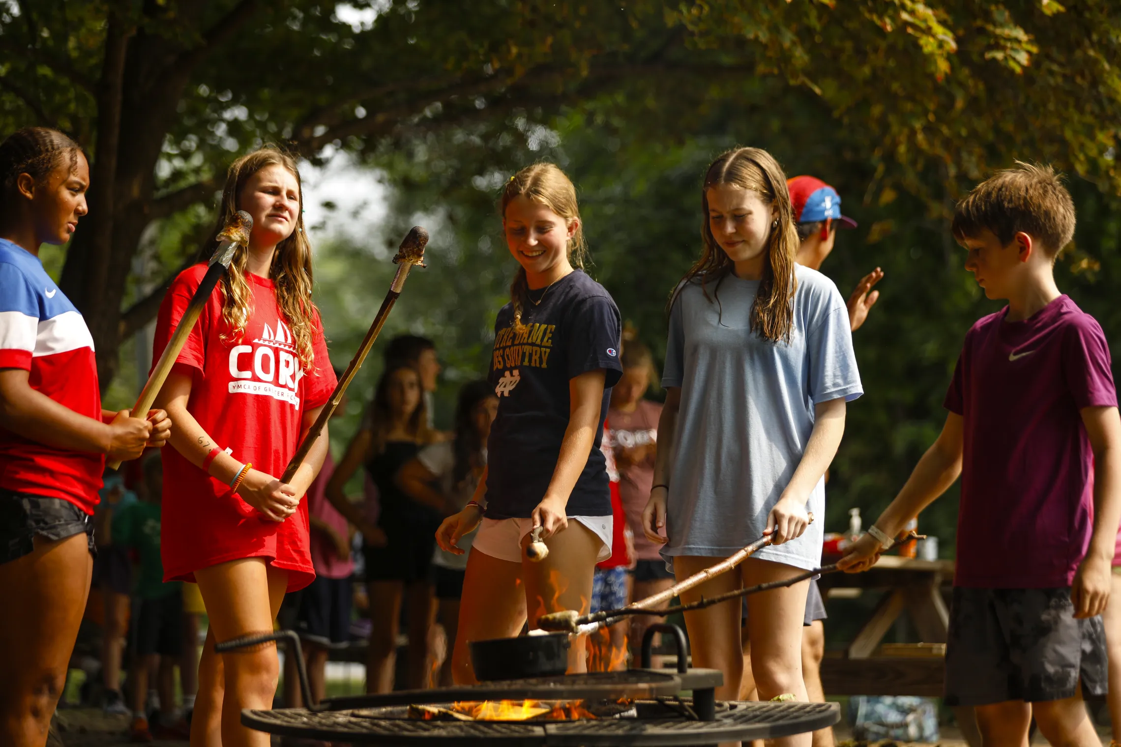 Campers roasting s'mores over campfire.