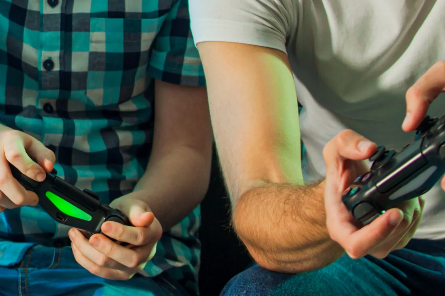 father and child playing video games together, holding controllers