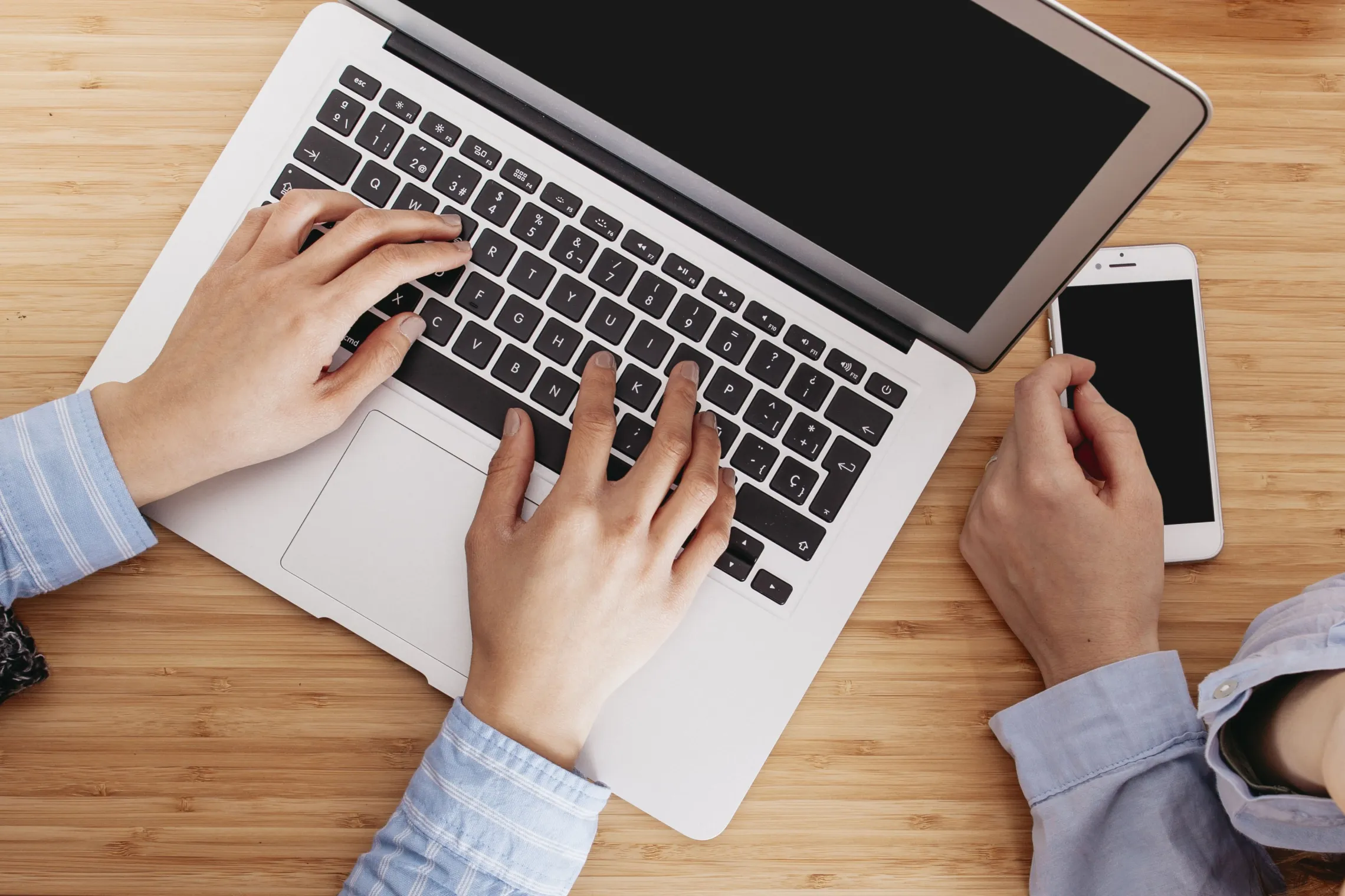 two people using a phone and a computer together