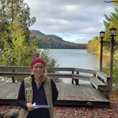 Jackie Rudolph, Executive Director of Camp Gorham posed in front of Darts Lake