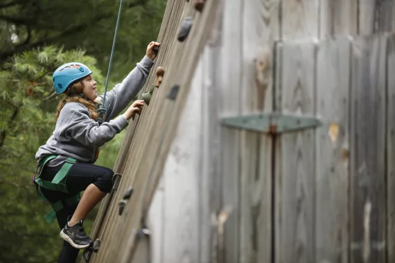 Camper climbing rock wall