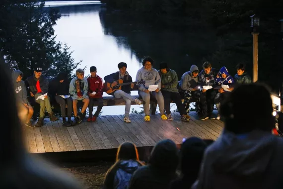 a group of campers putting on a musical performance at the night campfire at camp gorham