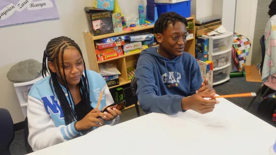 Thirteen-year-old Ahmari (right) sits in class during Power Scholars Academy.