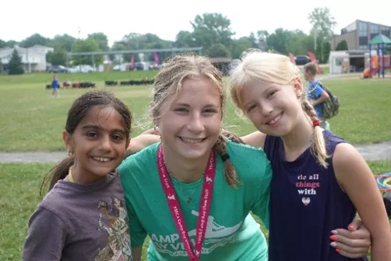 A Camp Bay View summer camp counselor poses with two campers