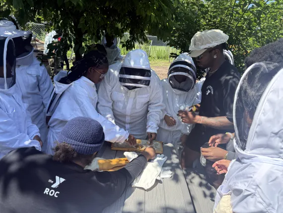 Power Scholars Academy campers learn beekeeping at Foodlink's Community Farm