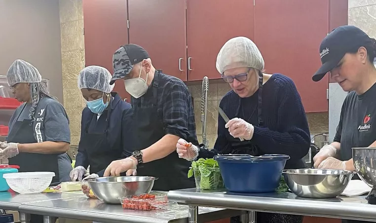 a group of foodlink volunteers cooking in the lily cafe