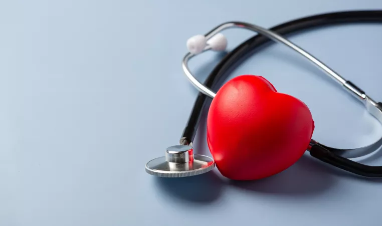 a foam heart with a stethoscope on a blue background